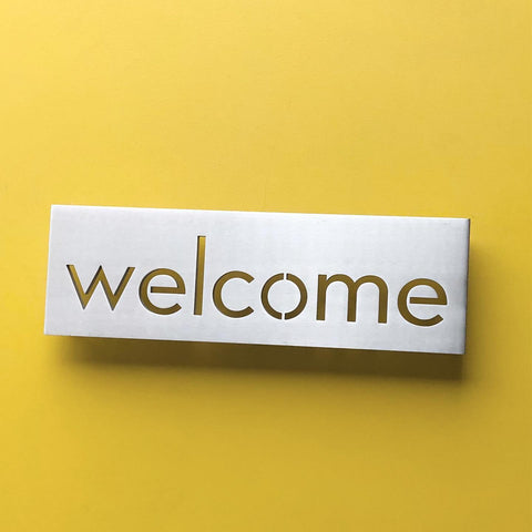 4" x 11" Welcome plaque on yellow background.