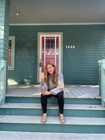 Rebekah Higgs sitting on the front steps of her craftsman home in Halifax Nova Scotia