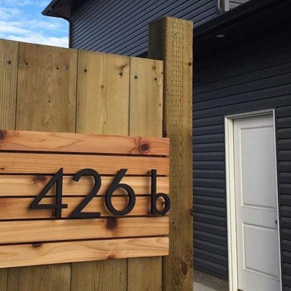 Modern House Numbers '426b' 8" Palm Springs numbers in Matte Black installed on a stained wood fence.