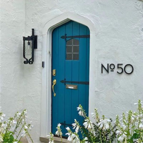 On Trend - NO 50 on a wall with blue door.