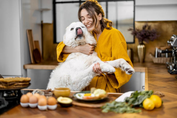 Woman hugging dog in kitchen