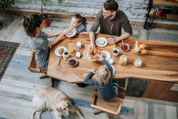 Family sitting at table with dog on floor