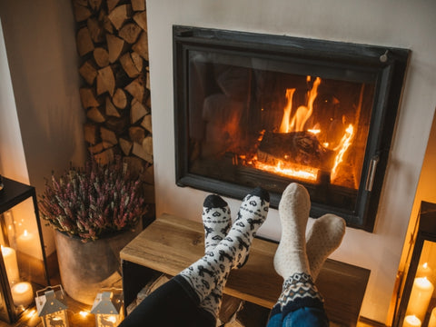 A Pair Of Feet In Socks By A Fireplace