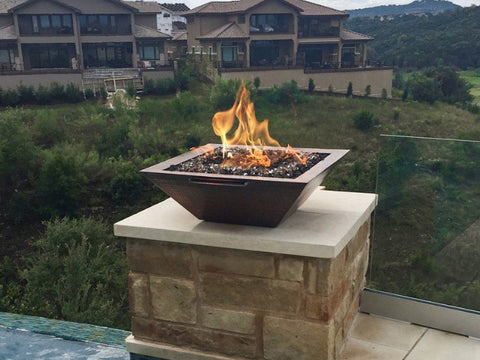 A Copper Fire Bowl On A Poolside Stone Pillar