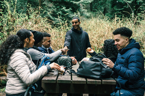 happy friends sitting on a picnic table