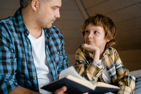 kid looking and listening to his father do a storytelling