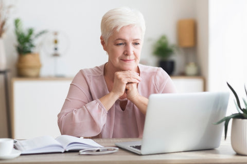 elderly woman looking at a laptop