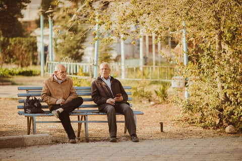 two old men talking at a park bench