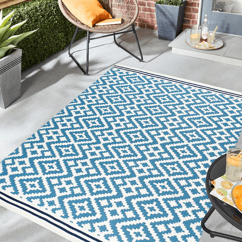 A blue aztec print rug in a garden patio