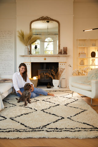 woman and dog sat on a white berber rug