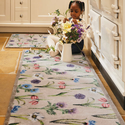 Girl Sitting on the floor with flowers on a Hug Rug