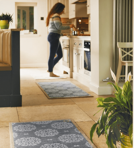 A woman stood in a kitchen decorated with kitchen runners