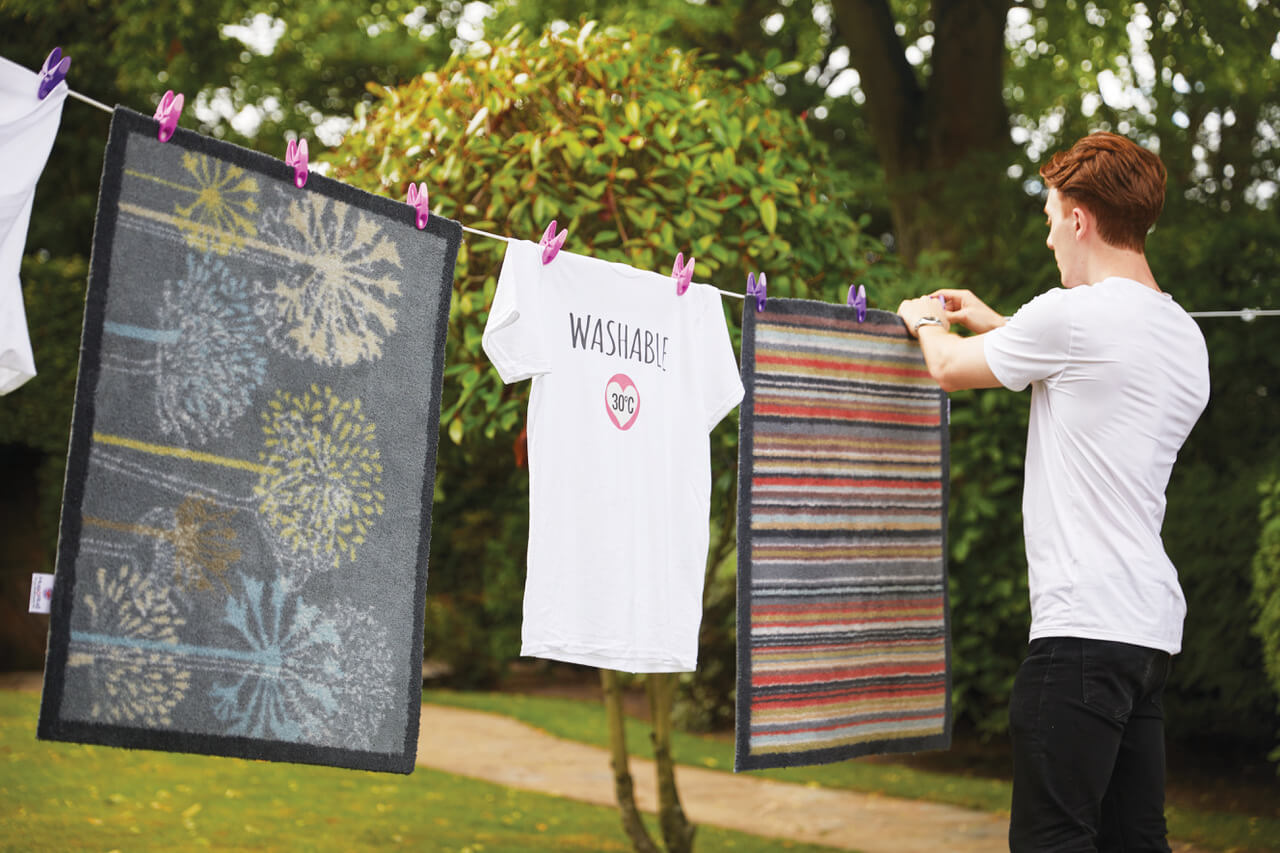 Washable doormats hung up on a washing line