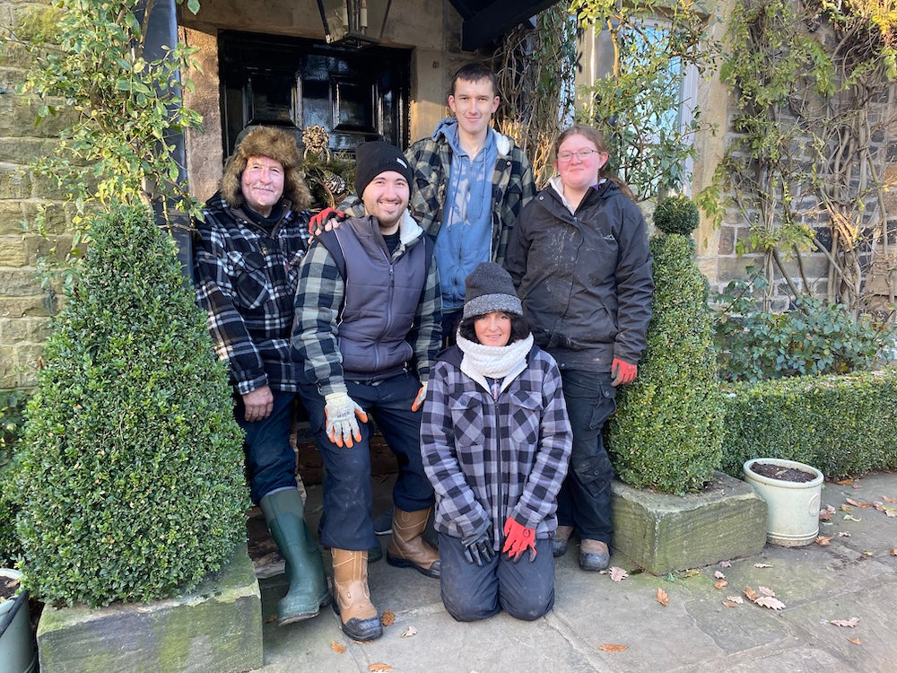 a group of 5 people stood outside in winter and gardening gear