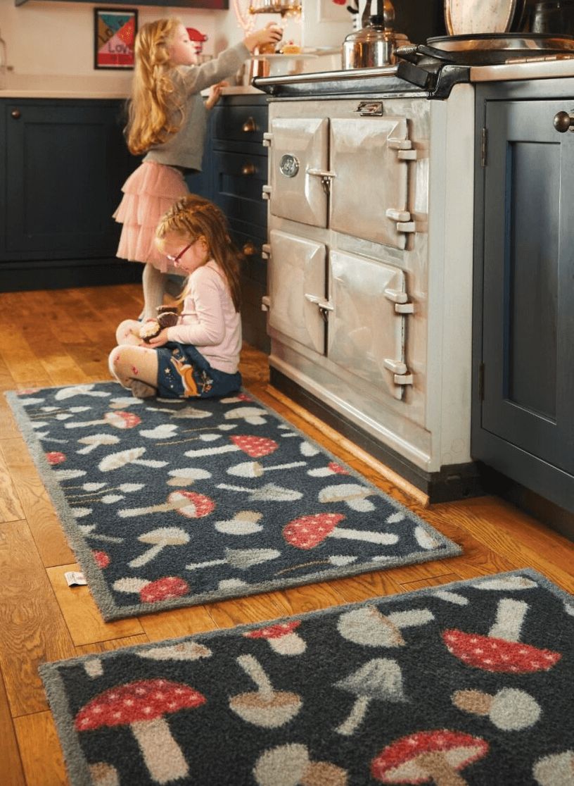 2 children in a kitchen sat on a mushroom kitchen runner mat