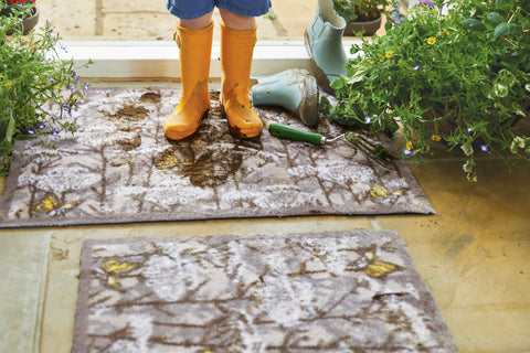 Muddy boots on a front door rug