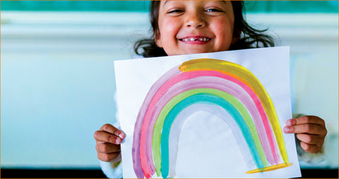 Girl holding rainbow drawing