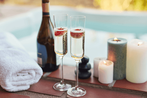 Two champagne glasses sat on the edge of a hot tub