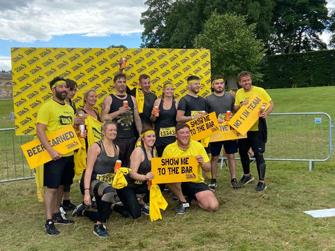 Hug at Home employees after completing Tough Mudder