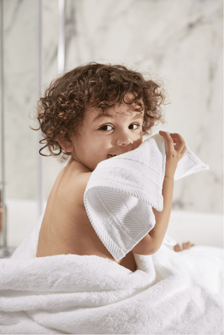 Boy cuddling white towel