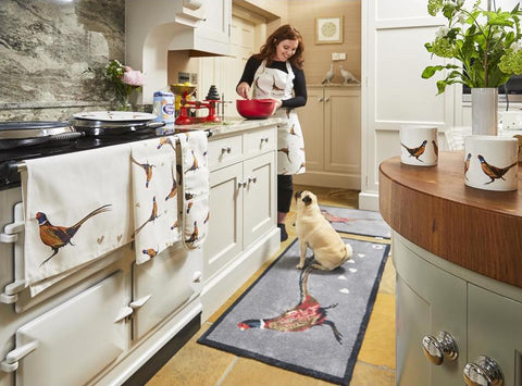 Woman cooking in kitchen with dog by her side
