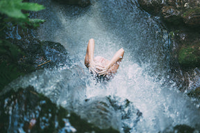 Woman under waterfall
