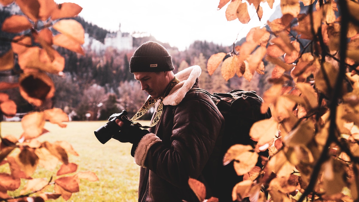 man holding camera in fall season