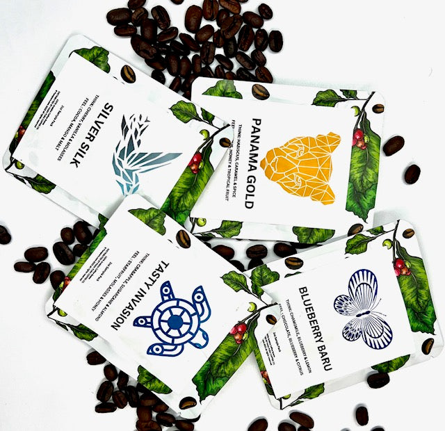 Assorted coffee packaging designs with coffee beans scattered around on a white background.