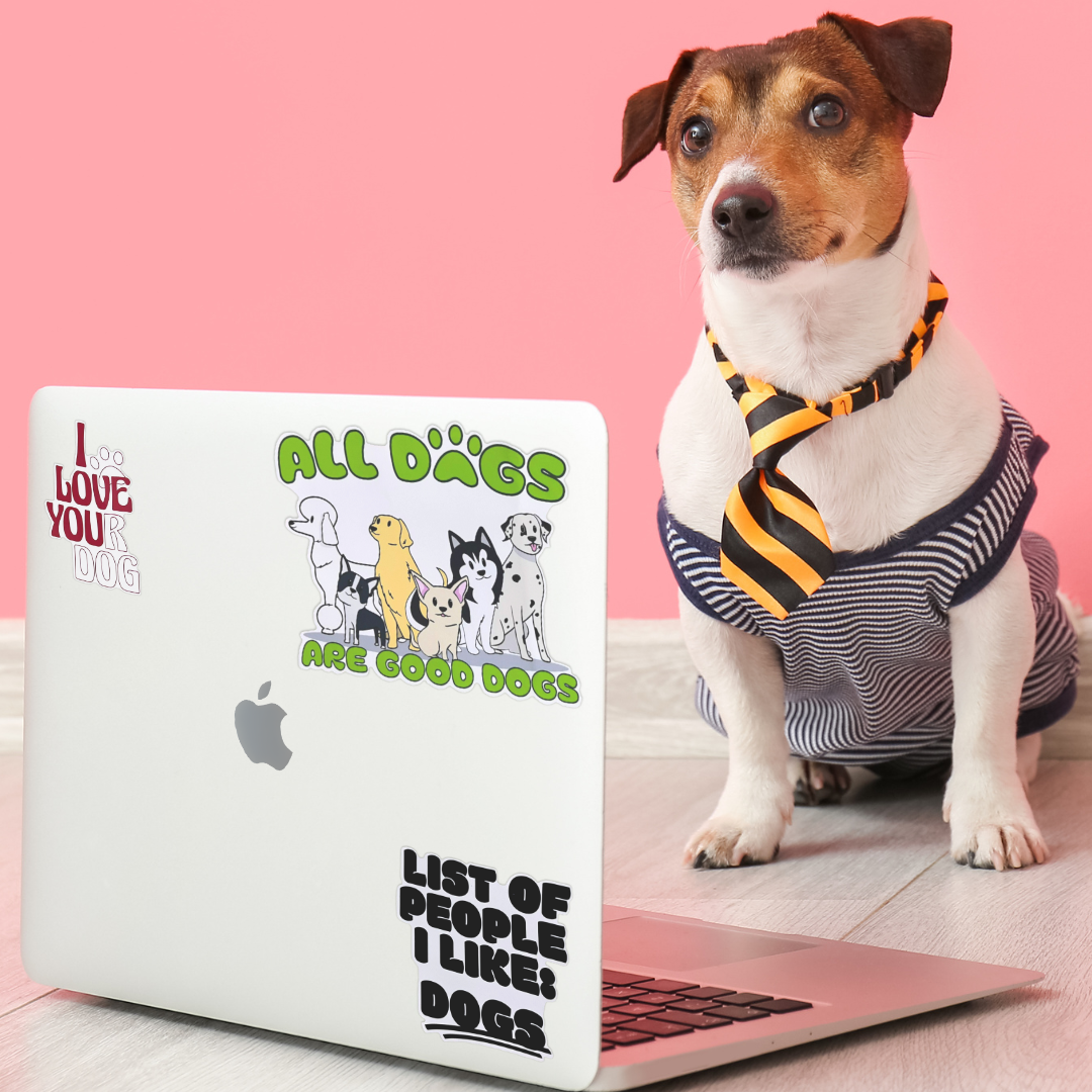 A dog wearing a striped tie sitting next to a laptop with dog-themed stickers.