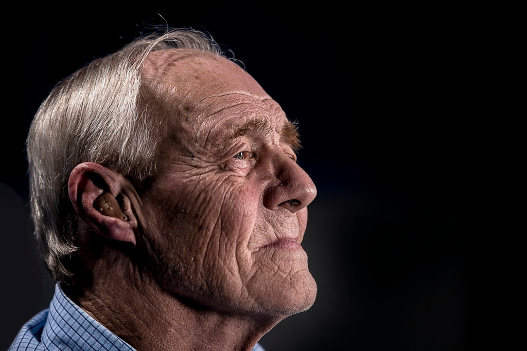 older man with hearing aid that isn't included in Medicare coverage