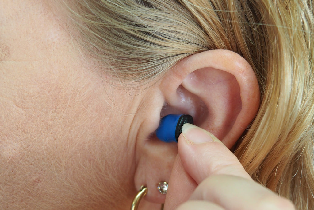 woman with hearing aid in ear - hearing aid covered by tricare