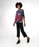 model in a straight leg black pant with a floral print button down blouse 