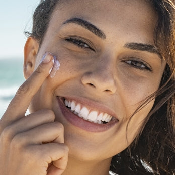 Model putting on face cream in the Avon Summer Shop.