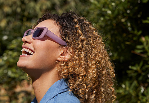 Model smiles with hands on her face.