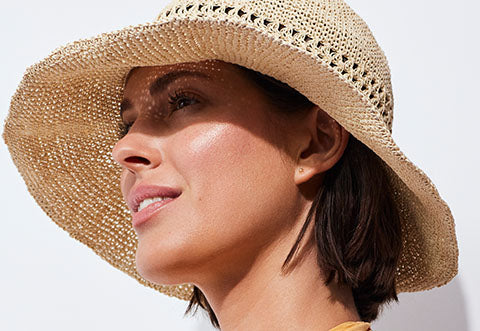 Model shields her face with hat.