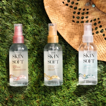 Three Skin So Soft dry oil bottles lie on the background of grass.