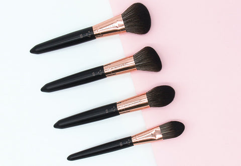 Make up brushes in a row on pink background