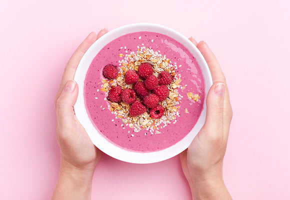 Pink smoothie bowl with fresh berries.