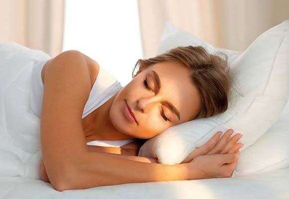 Model asleep in white bedding.