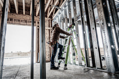 An individual using a combination ladder indoors.