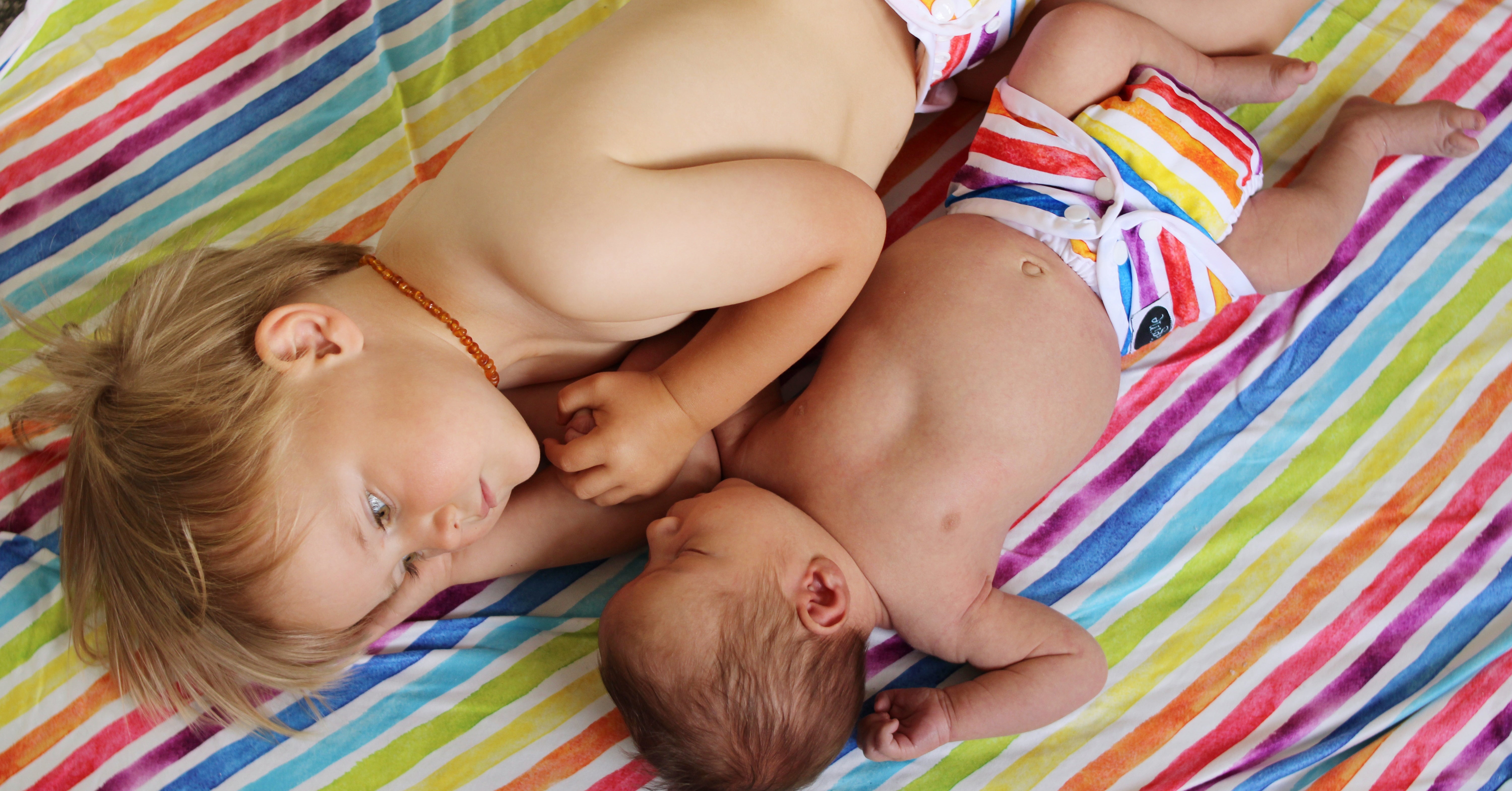 newborn siblings in cloth diapers