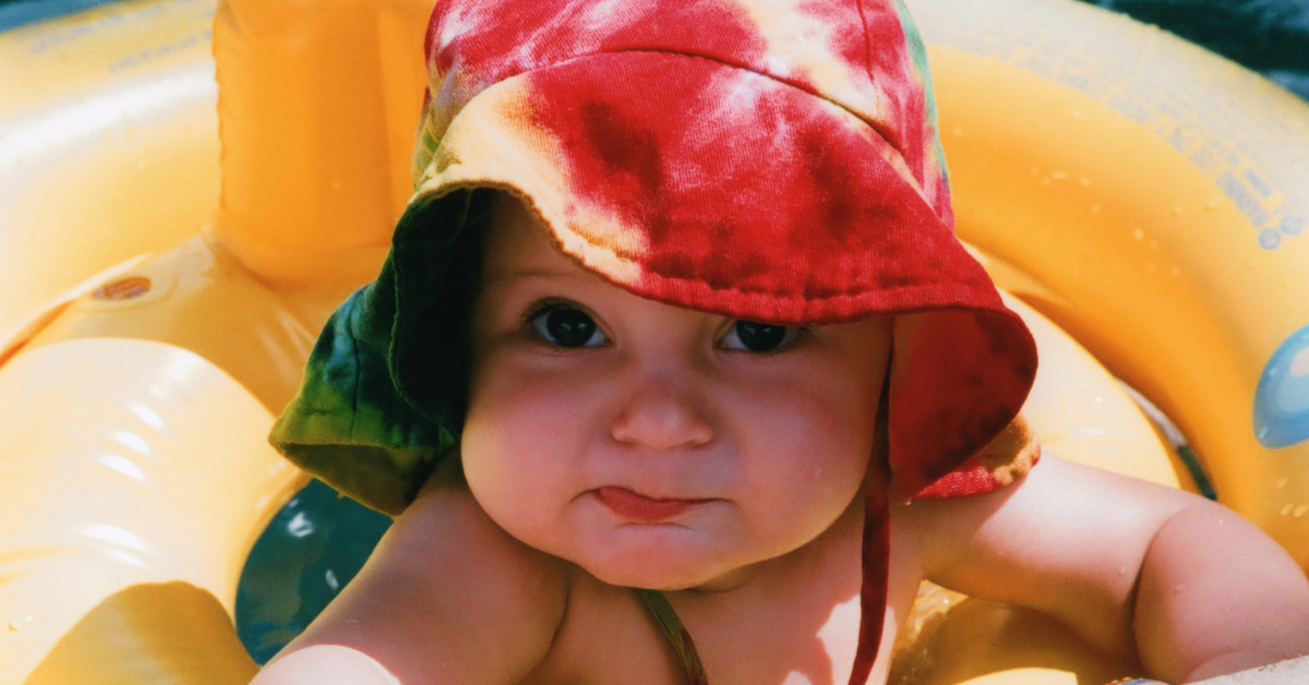 baby wearing a hat under the heat of the sun