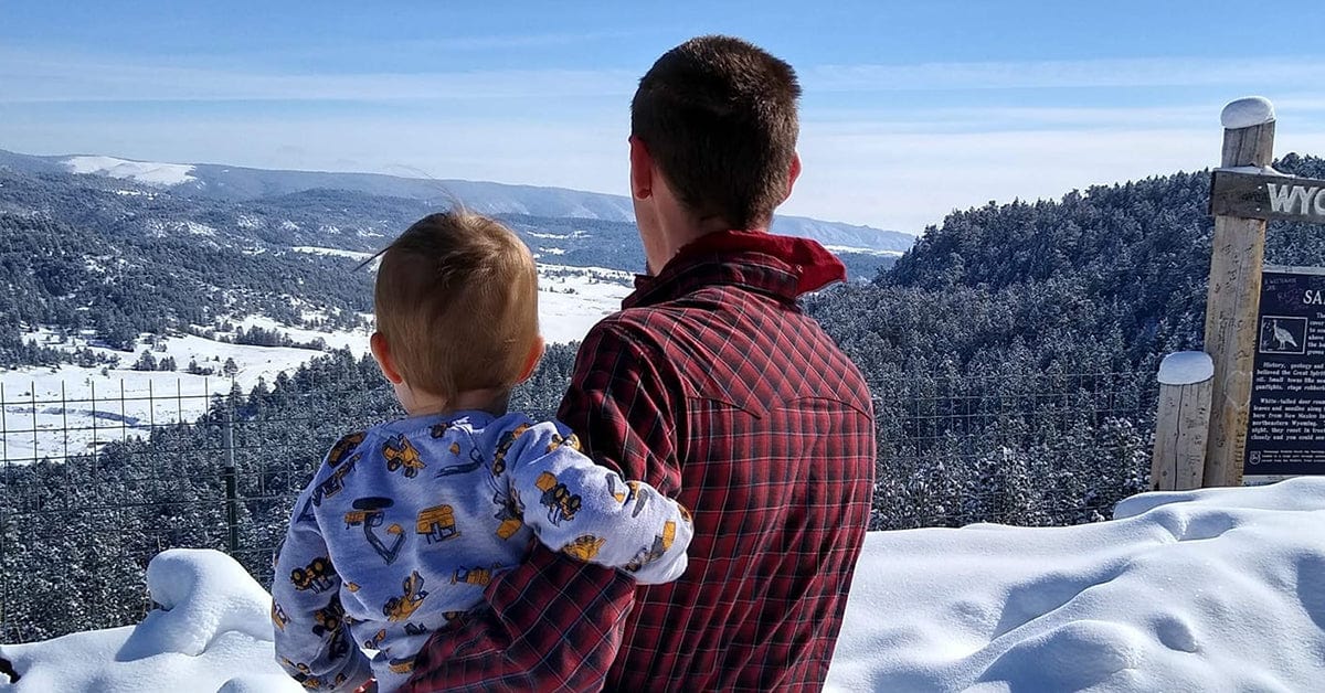 parent and child outdoors looking at snowy landscape