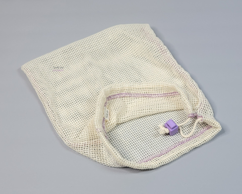 A cotton mesh bag on a grey background. 