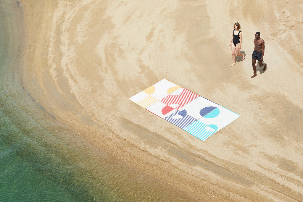 4 Connectable premium beach towels, connected to eachother in the beach. A wide space created by linked beachtowels. Style and color woven into premium beach towels made of 100% organic cotton. Highest quality and incredible texture, manufactured sustainably with utmost respect for the environment.
