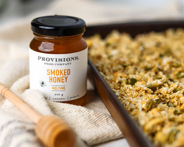 Smoked Honey Granola in a pan beside a jar of Provisions Smoked Honey