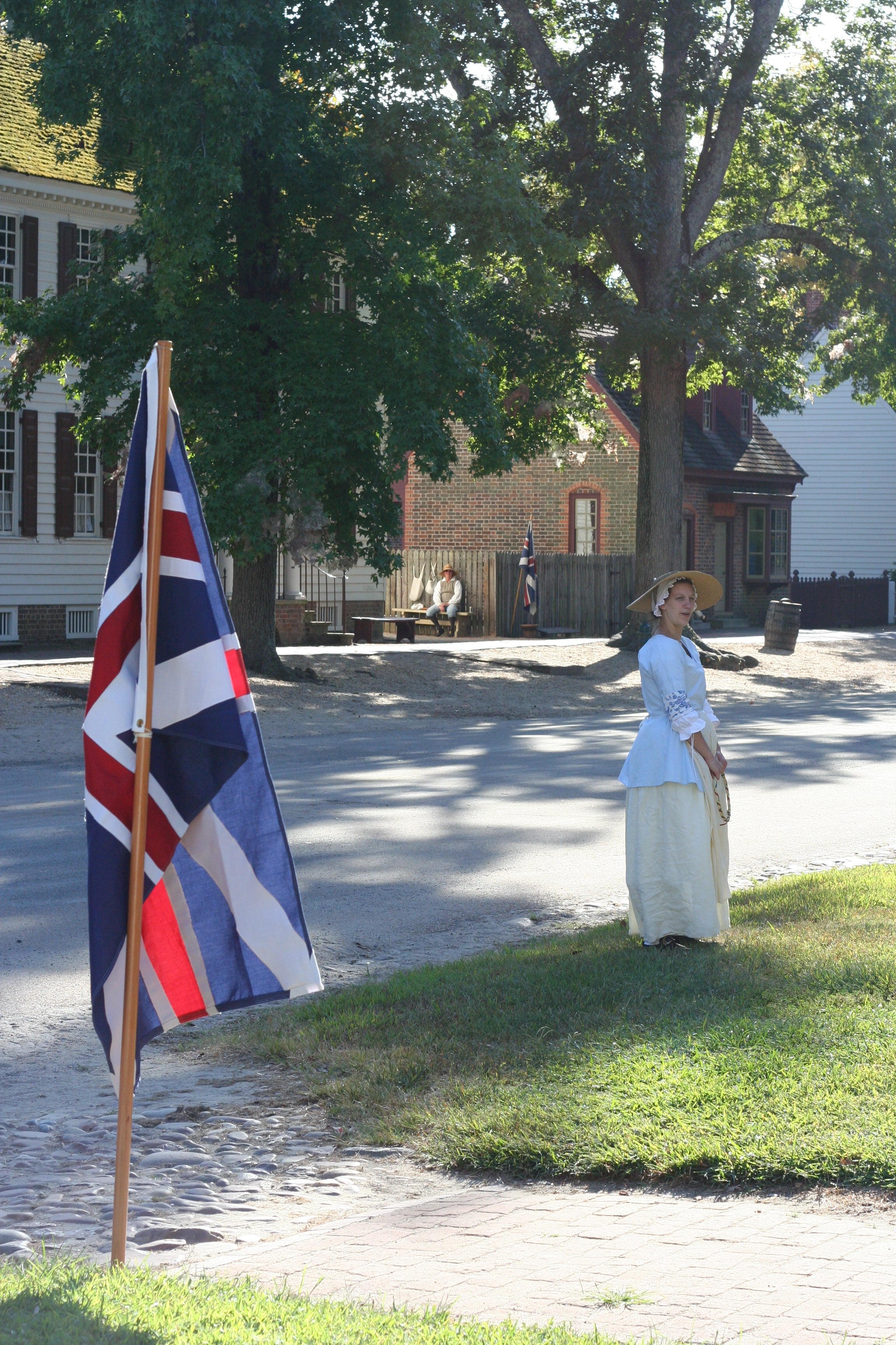 Woman in 18th century dress standing by Colonial American flag