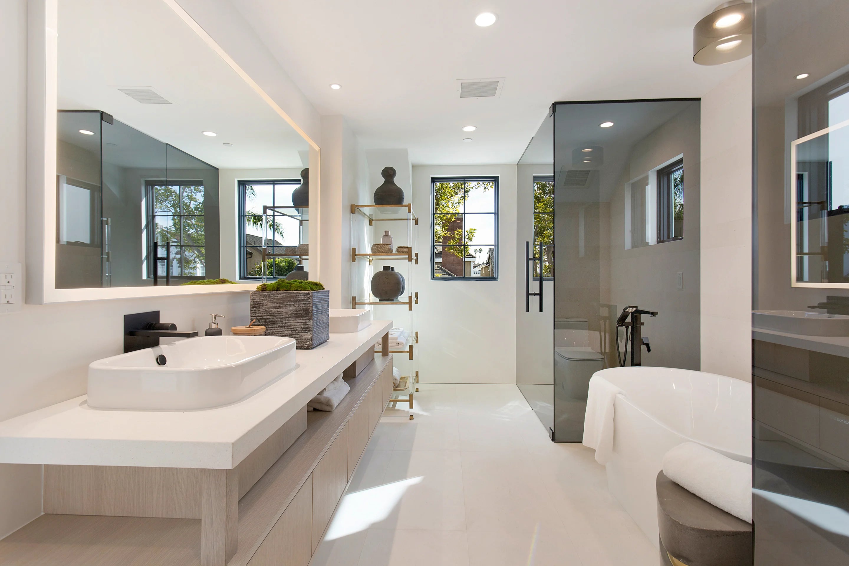 Gold and black contemporary bathroom features a brass waste basket