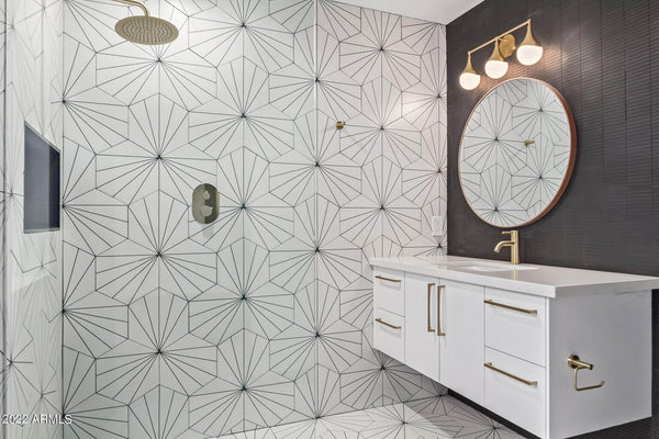 Satin brass faucets and shower in a geometrically tiled bathroom