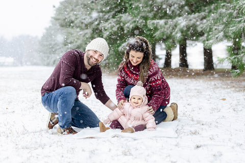 family posing in the snow for a christmas photo